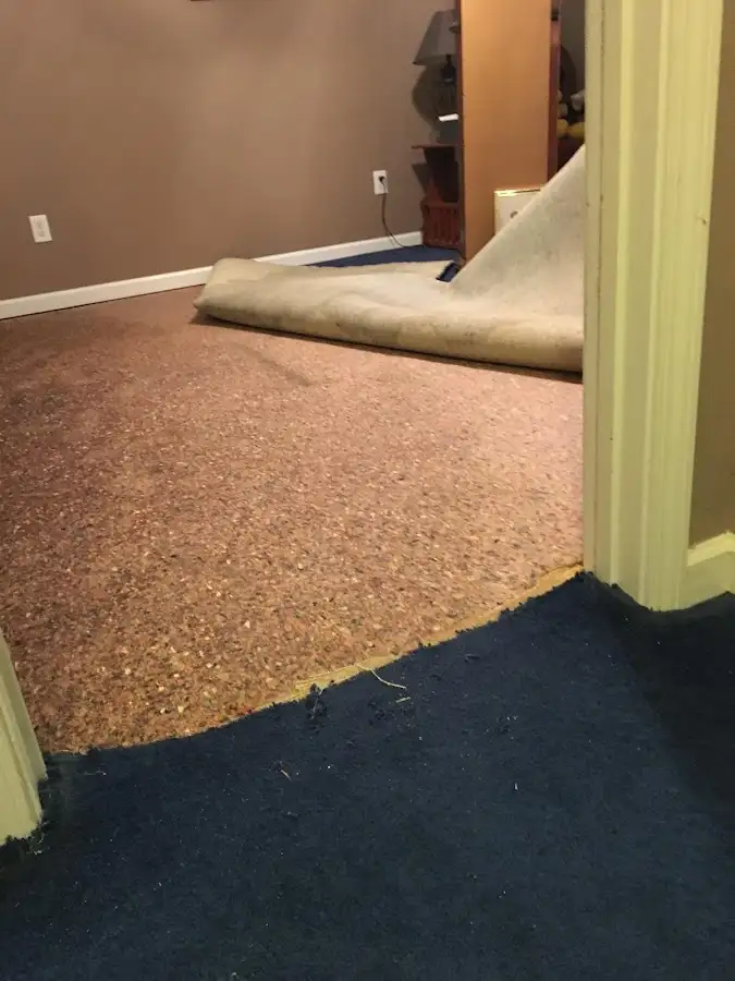 Carpet pad removal revealing water damage during Water Mitigation Services in Windham